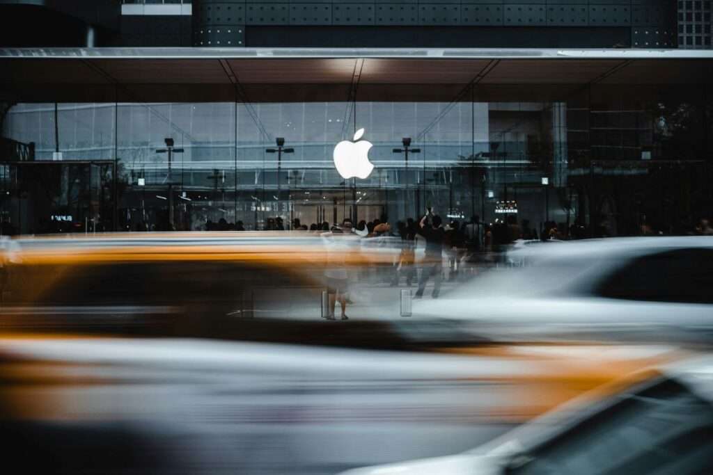 Blurry photo of cars driving past an Apple store.