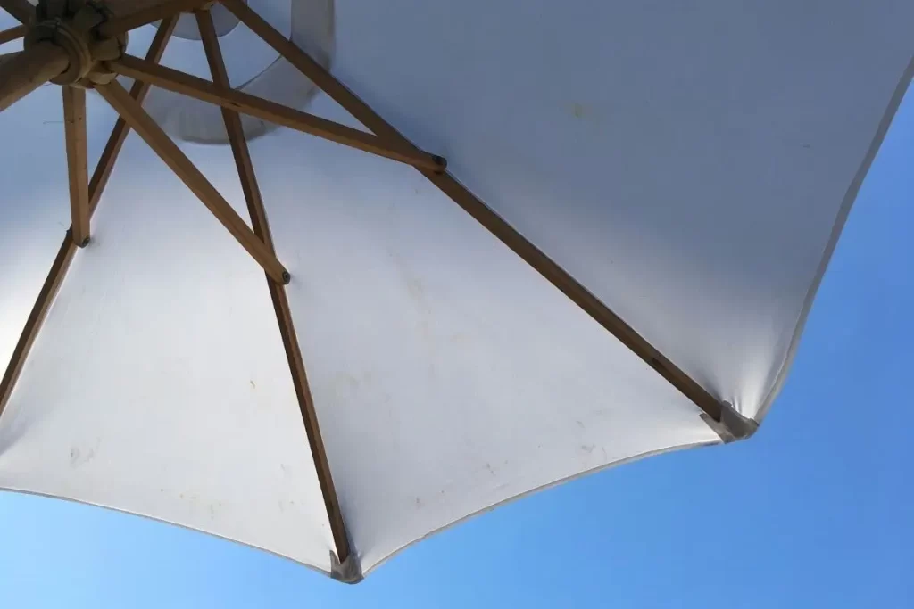 White beach umbrella against a clear blue sky.